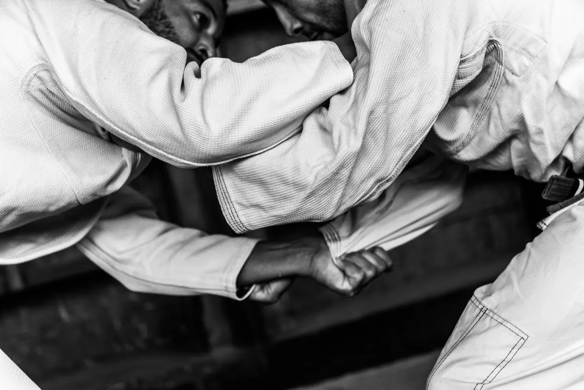 Gros plan en noir et blanc sur des mains qui saisissent le col d'un kimono